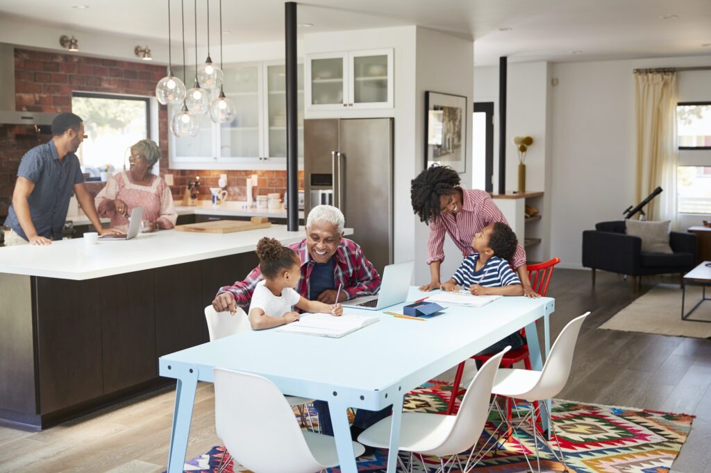 Children Doing Homework In Busy Multi Generation Family Home